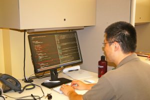 Man Working with Code on Desktop Computer