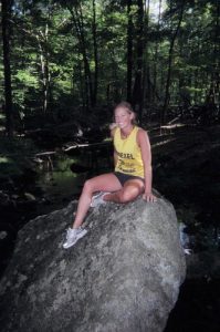 Girl Sitting on Large Rock in Woods